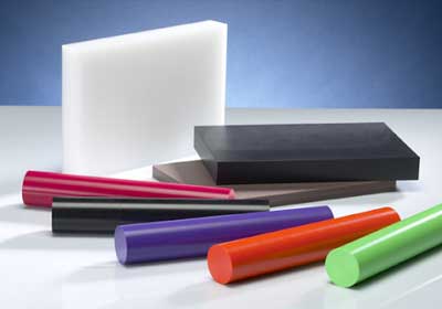 Close-up comparison of nylon and acetal plastic rods used in engineering applications