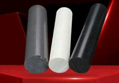 Different types of plastic rods including Acetal, Nylon, PTFE, and Tufnol displayed on a workbench
